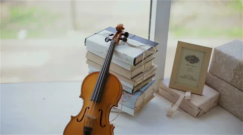 Beautiful decor in the studio, violin and books on the window Stock Footage 49743167