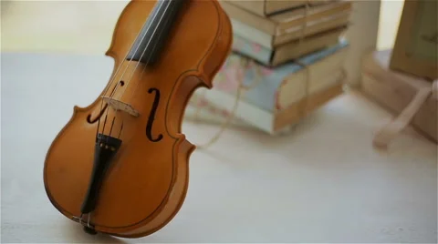 Beautiful decor in the studio, violin and books on the window Stock Footage 49743182