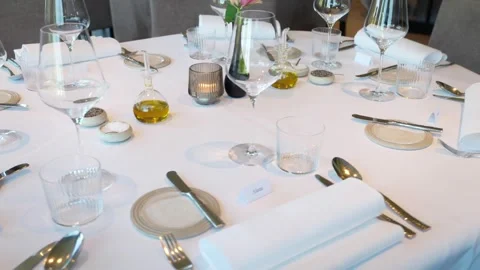 Beautiful decorated dining table with cutlery and empty wine glasses inside Stock Footage 335387770