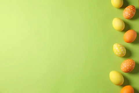 Beautiful decorated Easter eggs on light green background, flat lay. Space .. Foto stock