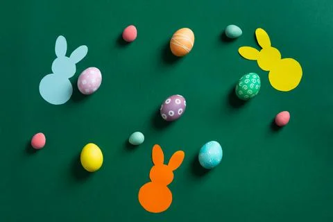 Beautiful different colorful Easter eggs with bunnies of paper on green 스톡 사진