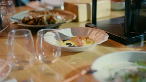 Beautiful dining wooden table with white plates and glasses. Stock Footage 233289955