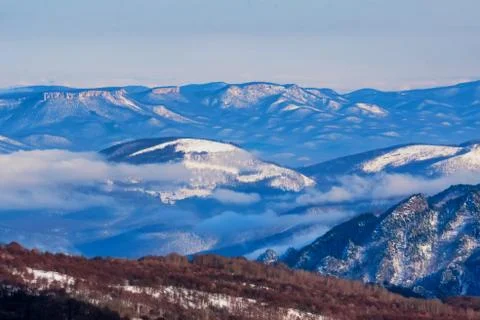 Beautiful distant winter mountains landscape with mist Stock Photos
