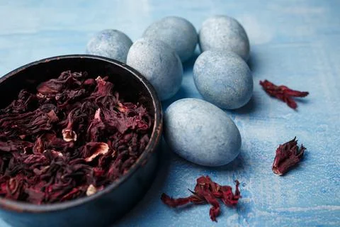 Beautiful DIY painted Easter eggs, dry Hibiscus tea in black bowl. Easter Stock Photos
