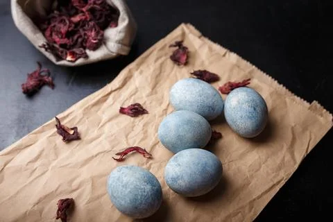 Beautiful DIY painted Easter eggs on craft paper, dry Hibiscus tea in burlap Foto stock
