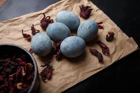 Beautiful DIY painted Easter eggs, dry Hibiscus tea in black bowl. Easter Stock Photos