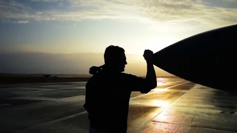 Beautiful dolly shot around Air Force pilot at sunset with his fighter jet. Stock Footage