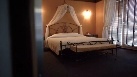 Beautiful double bed standing in a small cozy hotel room. Camera moves from left Video stock 101226773