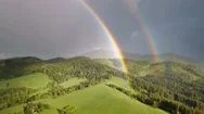 Beautiful Double Rainbow Moving Over Fresh Green Forest Landscape Aerial Stock Footage