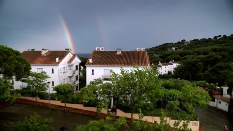 Beautiful double rainbow in the rainy sky. Rayny evening in a small coastal Stock Footage 132410705