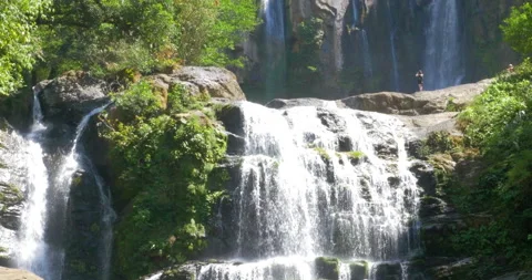 Beautiful Double Waterfalls Cascading Down With One Person Standing Between Stock Footage 138334031