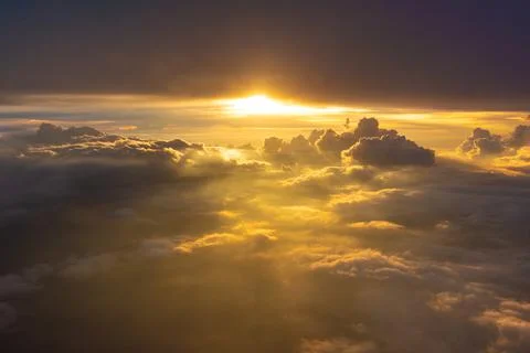Beautiful dramatic bird eye view of cloudscape with sunset as seen from a pla Stock Photos