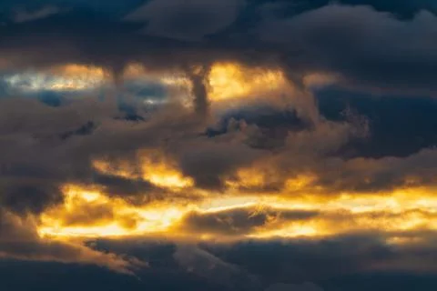 Beautiful dramatic clouds in sky illuminated by rays of sun at sunset to change Stock-Fotos