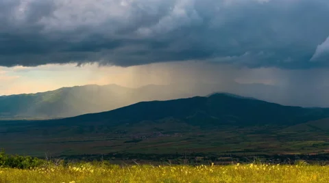 Beautiful dramatic landscape storm heavy rain sun beams mountains clouds Stock Footage