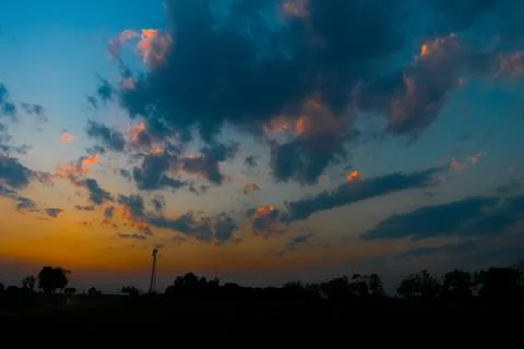 A beautiful dramatic sky after sunset full of clouds with fiery orange and bl Stock Photos