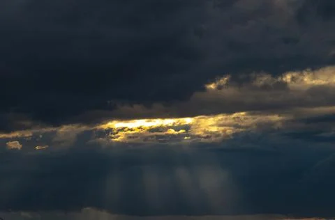 Beautiful dramatic sky with sunbeams through the clouds at sunset Stock Photos