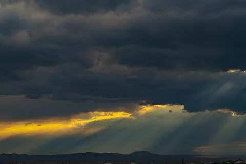 Beautiful dramatic sky with sunbeams through the clouds at sunset Stock Photos