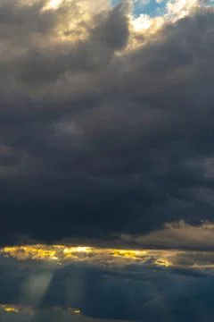 Beautiful dramatic sky with sunbeams through the clouds at sunset Stock Photos