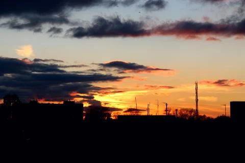 Beautiful dramatic sunset with dark clouds over the city silhouette Foto stock