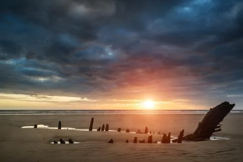 Beautiful dramatic sunset landscape over shipwreck on rhosilli bay beach Stock Photos