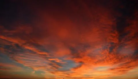 Beautiful dramatic sunset with  orange sky and awesome golden reflection. Stock Photos