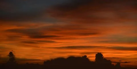 Beautiful dramatic sunset with  orange sky and awesome golden reflection. Stock Photos