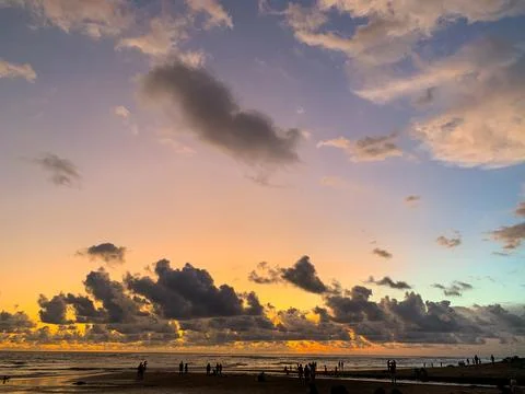 Beautiful dramatic sunset over the sea. Peoples silhouettes on the beach Stock Photos