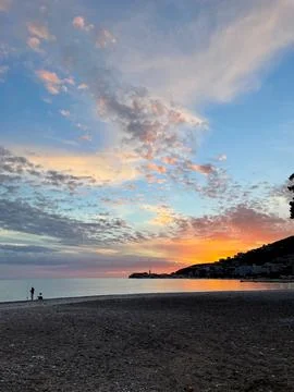 Beautiful dramatic sunset over the sea and mountain. Fisherman silhouette Stock-Fotos