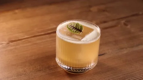 A beautiful drink with an ice cube on the bar counter slow motion bar Stock Footage 176389767