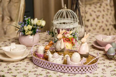 Beautiful Easter pastel decorations with table setting. Porcelain rabbits and Stock Photos