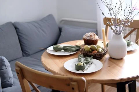 Beautiful Easter table with pastries, willow branches, eggs and candles. Stock Photos