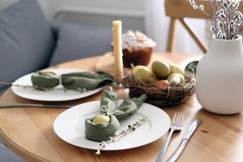 Beautiful Easter table with pastries, willow branches, eggs and candles. Stock Photos