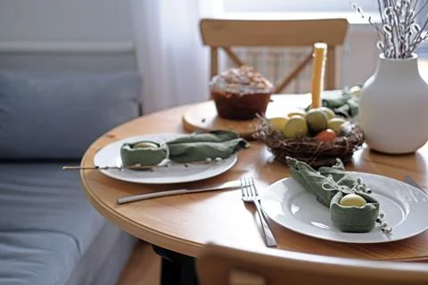 Beautiful Easter table with pastries, willow branches, eggs and candles. Stock-Fotos