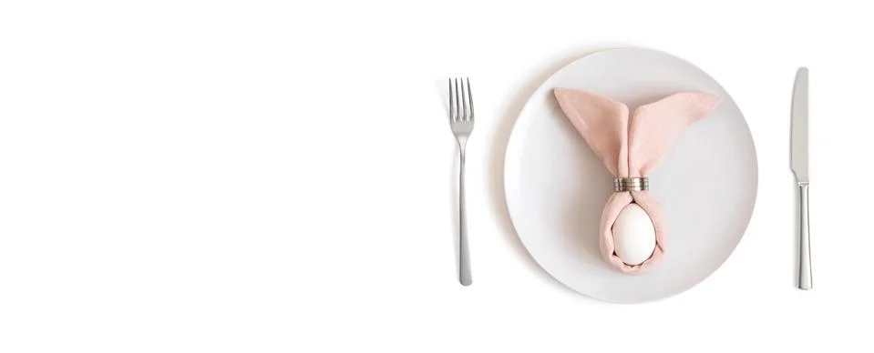 Beautiful Easter table setting with a white egg on a pink napkin with rabbit  Stock Photos