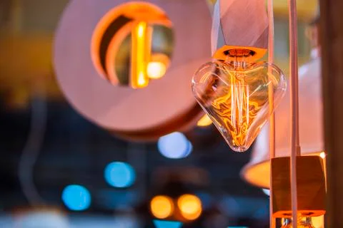 A beautiful Edison light bulb in the shape of a heart. Festive cute heart sha Stock Photos