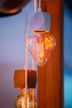 A beautiful Edison light bulb in the shape of a heart. Festive cute heart sha Stock Photos