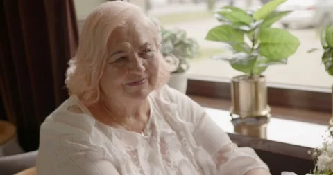Beautiful elderly couple hold hands in a cafe and look lovingly at each other Vídeo Stock 229717660