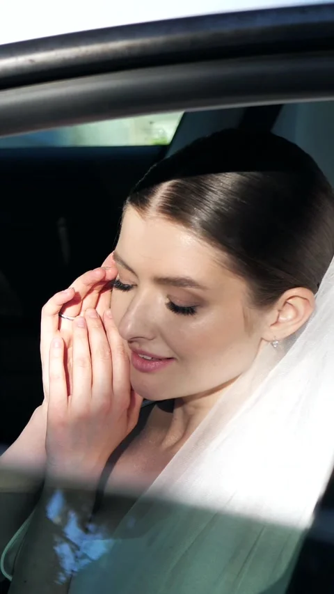 Beautiful elegant bride sitting in a car and smiling gently close up. Stock Footage 340359582