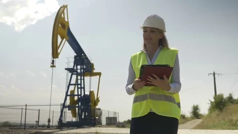 Beautiful engineering woman evaluator working on her digital tablet in oilfie Stock Footage 82179280