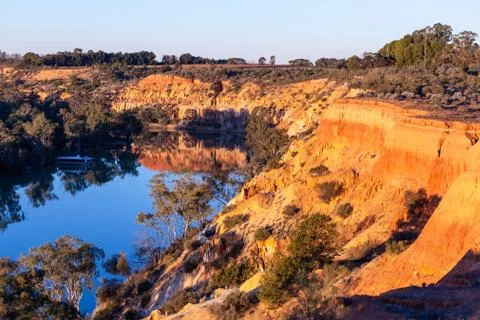 Beautiful eroding sandstone cliffs over Murray River glowing in sunset and re Foto stock