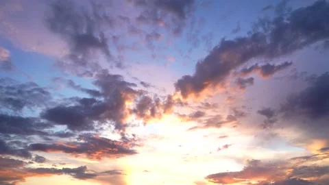 Beautiful evening blue sky at sunset with flaming bright light clouds. A warm su Stock Footage 156725820