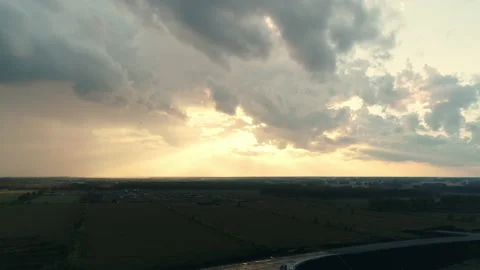 Beautiful evening clouds over a road junction in the fields. The rays of the sun Stock Footage 138046878
