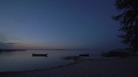Beautiful evening or night landscape with shore, beach, reeds, fishing wooden Stock Footage 240734415