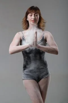 Beautiful expressive ballet dancer posing with flour at studio Stock Photos