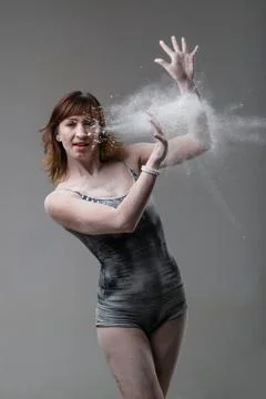 Beautiful expressive ballet dancer posing with flour at studio Stock Photos