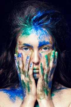 Beautiful face with colored paint on a black background Stock Photos