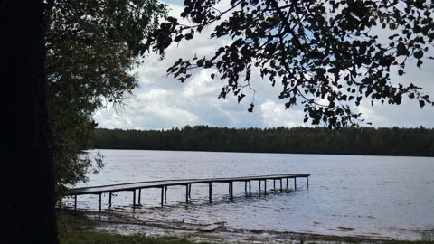 A beautiful fall landscape on a pier by a forest lake. Stock Footage 220564823