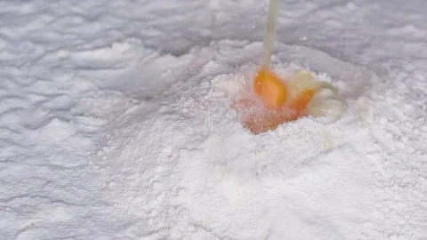 Beautiful falling eggs into flour falling in one place in one funnel flour Stock Footage 231060525