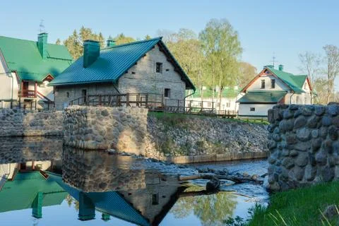 Beautiful farm reflected in the river on background of blue sky Stock Photos