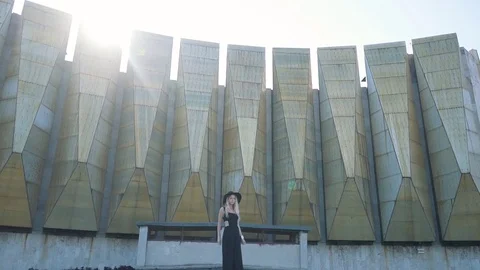 Beautiful fashion girl in black dress posing and smiling at camera on urban Stock Footage
